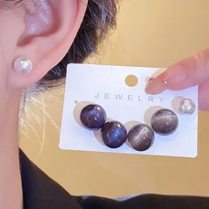 Minimalist round resin pearl earrings with silver needles for a stylish look.