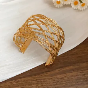 Primo piano di un bracciale a fascia in metallo dorato intrecciato su più strati