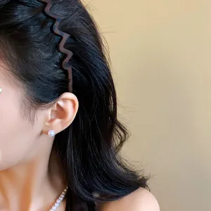 Detailed macro view of a retro matte wavy leopard print headband on a model's hair