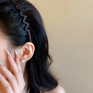 Detailed view of a stylish retro matte wave leopard print headband on dark hair
