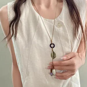 Bohemian ethnic necklace with ceramic oval bead and metal leaf on model worn