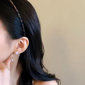 Detailed view of vintage matte wavy leopard print headband on model's hair.