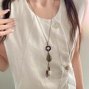 Detailed view of bohemian retro ceramic necklace with bronze leaf and bead accents