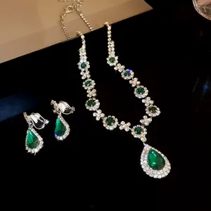 Elegante set di collana e orecchini con gocce verde smeraldo e strass scintillanti.
