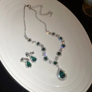 Primo piano di collana vintage di lusso con pendente a goccia verde e orecchini abbinati