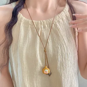 Close-up of bohemian style ceramic necklace featuring a cute garlic character pendant