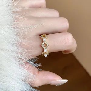 Primo piano elegante di un anello a fiore placcato oro 18 carati con zirconi e perle
