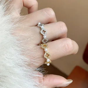 Primo piano di un elegante anello a fiore in oro 18k con zirconi e perle luccicanti