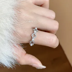 Dettaglio ravvicinato di un elegante anello d'argento con fiori di zircone e perle