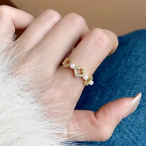 Vista dettagliata di un anello con fiori in perle e zirconi placcato oro 18k al dito