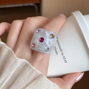 Detailed shot of a trendy chunky resin ring embedded with colorful rhinestones on a finger