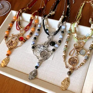 Close-up of multi-layer ethnic style beaded necklaces with vintage coin pendants.