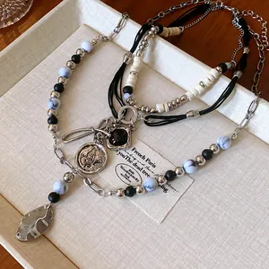 Close-up of multi-layer ethnic beaded necklace with vintage butterfly coin pendant
