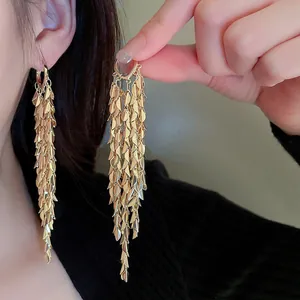 Detailed view of elegant gold leaf sequin tassel earrings with shimmering statement drapes