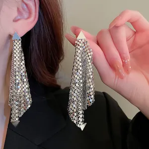 Close-up of sparkling silver sequin tassel earrings showing detailed mesh texture