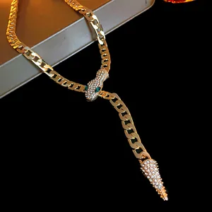 Close-up of gold-toned snake necklace featuring sparkling rhinestones and green gem eyes.