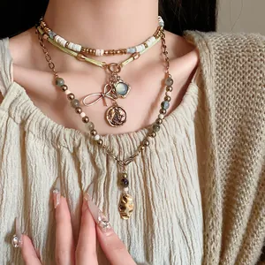 Detail view of layered ethnic beaded necklace with vintage butterfly and coin pendants
