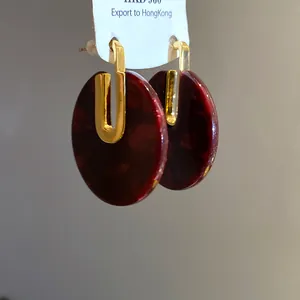 Dettaglio orecchini tondi in acetato rosso scuro placcati oro 18 carati