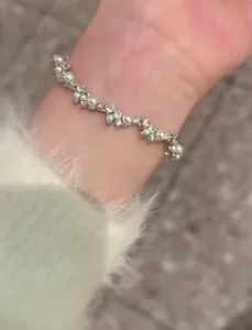 Detailed view of delicate irregular bracelet featuring white pearls and clear cubic zirconia