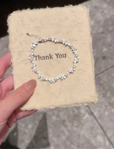 Close-up detail of Korean style irregular zircon and pearl bracelet on beige display card