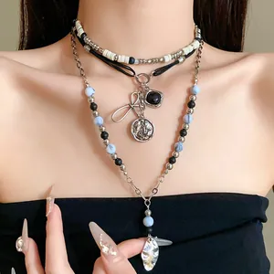 Detailed view of ethnic beaded multi-layer necklace featuring bow and silver coin pendants