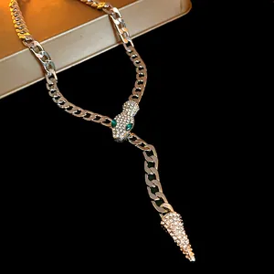 Detailed view of silver snake-shaped necklace with rhinestones and green eyes