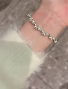 Close-up of elegant pearl and zircon bracelet on wrist with fuzzy sweater sleeve