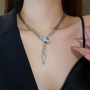 Detailed view of a silver curb chain necklace with a rhinestone-encrusted snake design.
