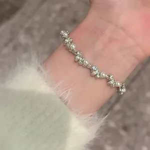 Detailed view of an irregular Korean style zircon pearl bracelet on a delicate wrist