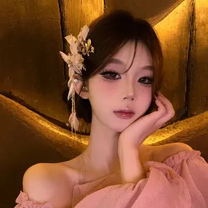 Detailed view of elegant flower hair clip with pearls and tassels worn by a model