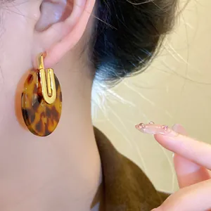 Dettaglio di orecchini ovali in acetato tartarugato su modella asiatica da vicino