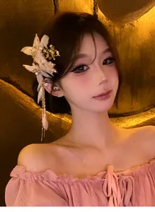 Dettaglio di un elegante fermaglio per capelli in tessuto con strass e lunghe nappe