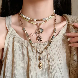 Detailed view of the ethnic style multi-layered necklace featuring bow and coin pendants
