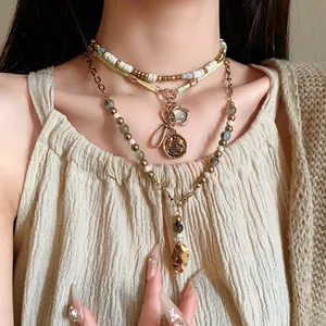 Detail of ethnic layered beaded necklace with vintage bow and coin pendants