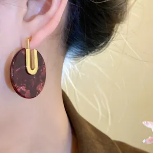 Vista dettagliata di orecchini tondi in acetato tartarugato con placcatura in oro 18K