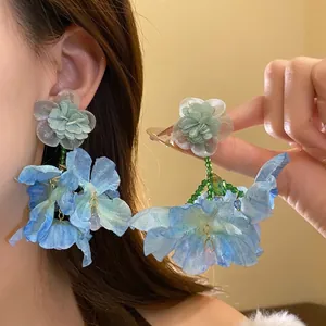 Eleganti orecchini pendenti con fiori in chiffon blu per un look da vacanza romantico.