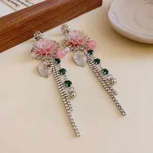 Detail view of elegant floral tassel earrings with pink crystals and green rhinestones.