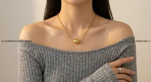 Minimalist long gold necklace with a polished round pendant for autumn/winter outfits