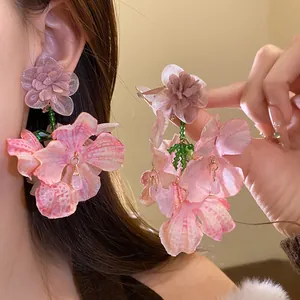 Dettaglio dei raffinati orecchini a fiore in chiffon rosa con perline verdi