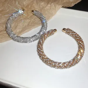 Detailed view of sparkling rhinestone-encrusted gold and silver open cuff bangles