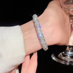 Close-up of a luxury rhinestone-encrusted bangle on a wrist with sparkling details.