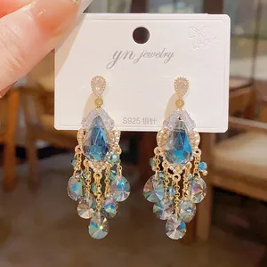 Detailed view of vintage teardrop tassel earrings featuring blue crystals and silver needles.