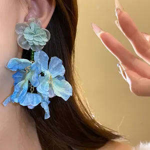 Vista dettagliata degli orecchini a fiore in chiffon blu con delicati pendenti di perle