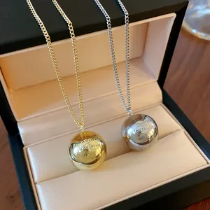 Detailed view of gold and silver sphere pendants with romantic engraving in box