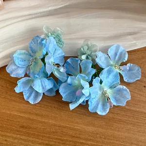 Vista dettagliata di orecchini a fiore in chiffon blu con eleganti ciondoli di perline