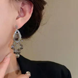 Elegant silver needle zircon teardrop glass bead tassel earrings worn by a model