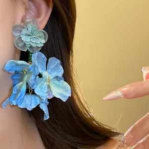 Vista dettagliata di orecchini a pendente con fiori in chiffon blu fatti a mano per vacanze