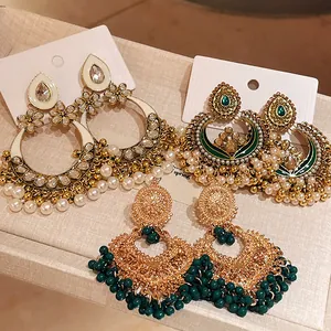 Detailed view of vintage ethnic-style gold earrings with pearls and floral motifs