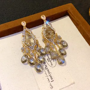Elegant close-up view of gold zircon and waterdrop glass bead tassel drop earrings