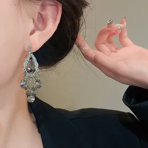 Close-up of elegant chandelier earrings with teardrop crystal and grey faceted beads